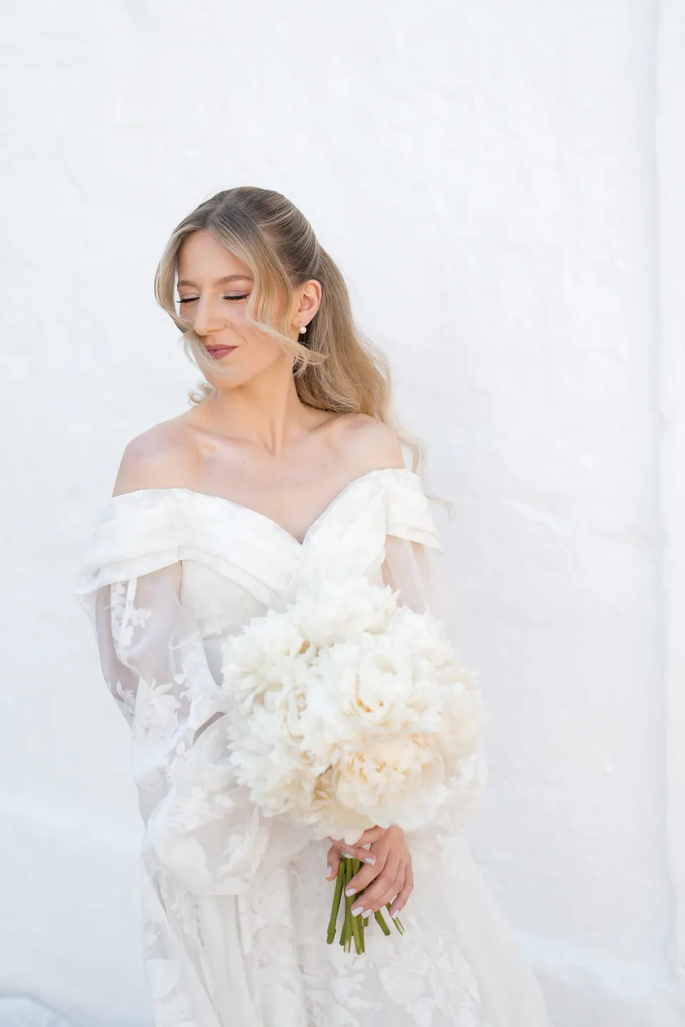 La novia sostiene su ramo con luz natural.