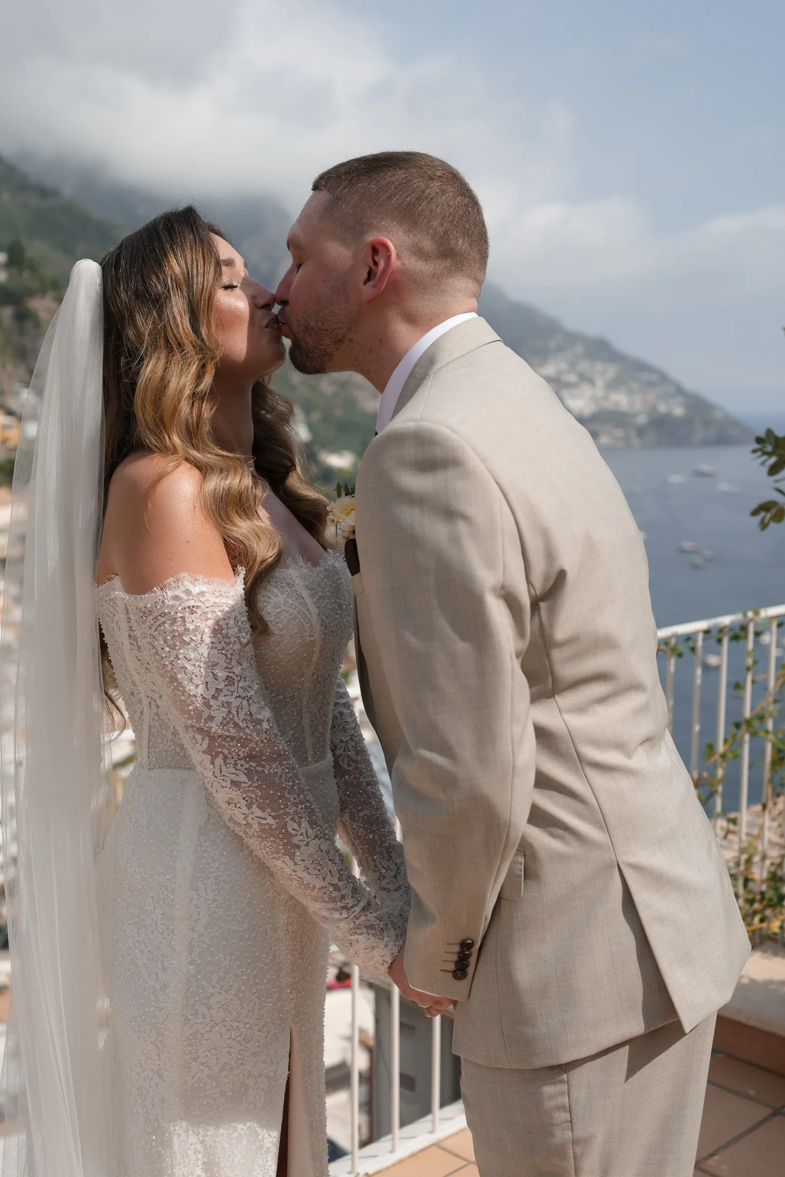 Couple kissing after their vows on a terrace high above Positano.