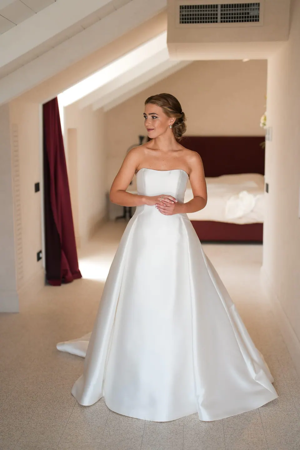 Die Braut im Kleid im Dachzimmer.