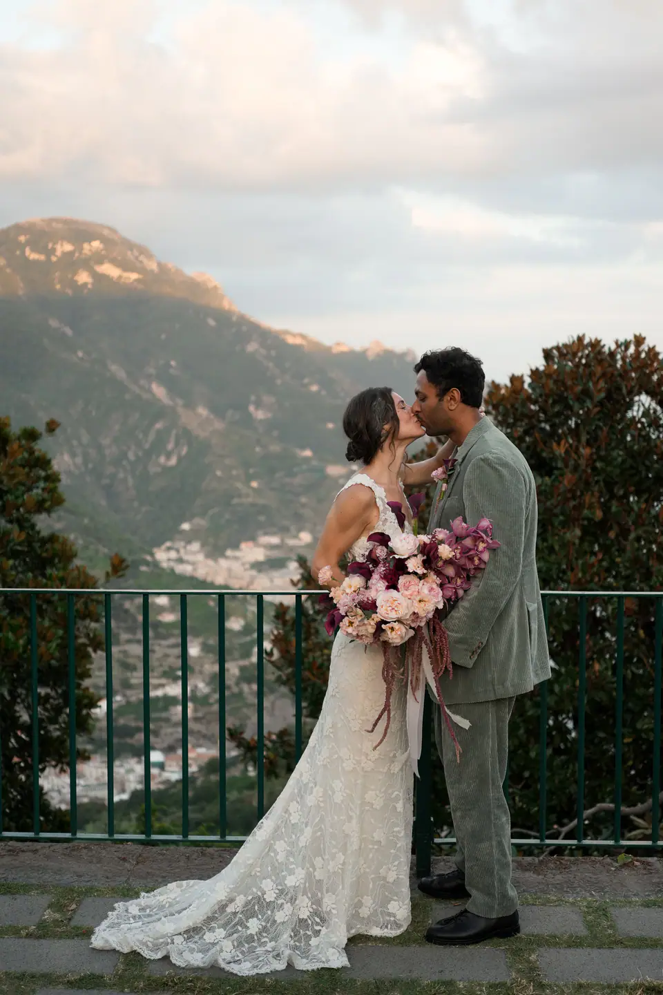 Couple embracing after their vows on a terrace in Ravello, the coast below at sunset.