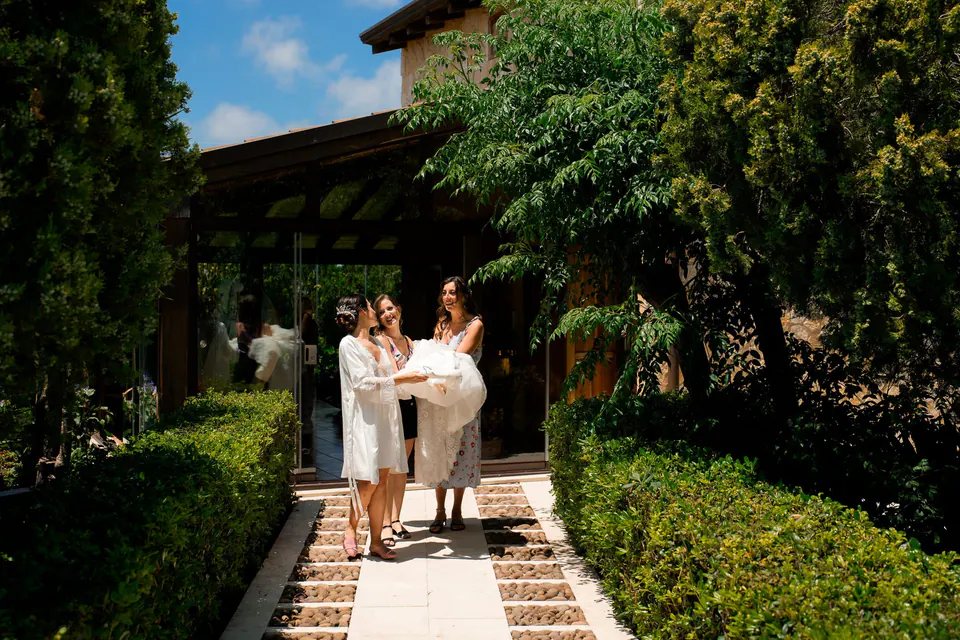 Bride and a woman walking along a garden path