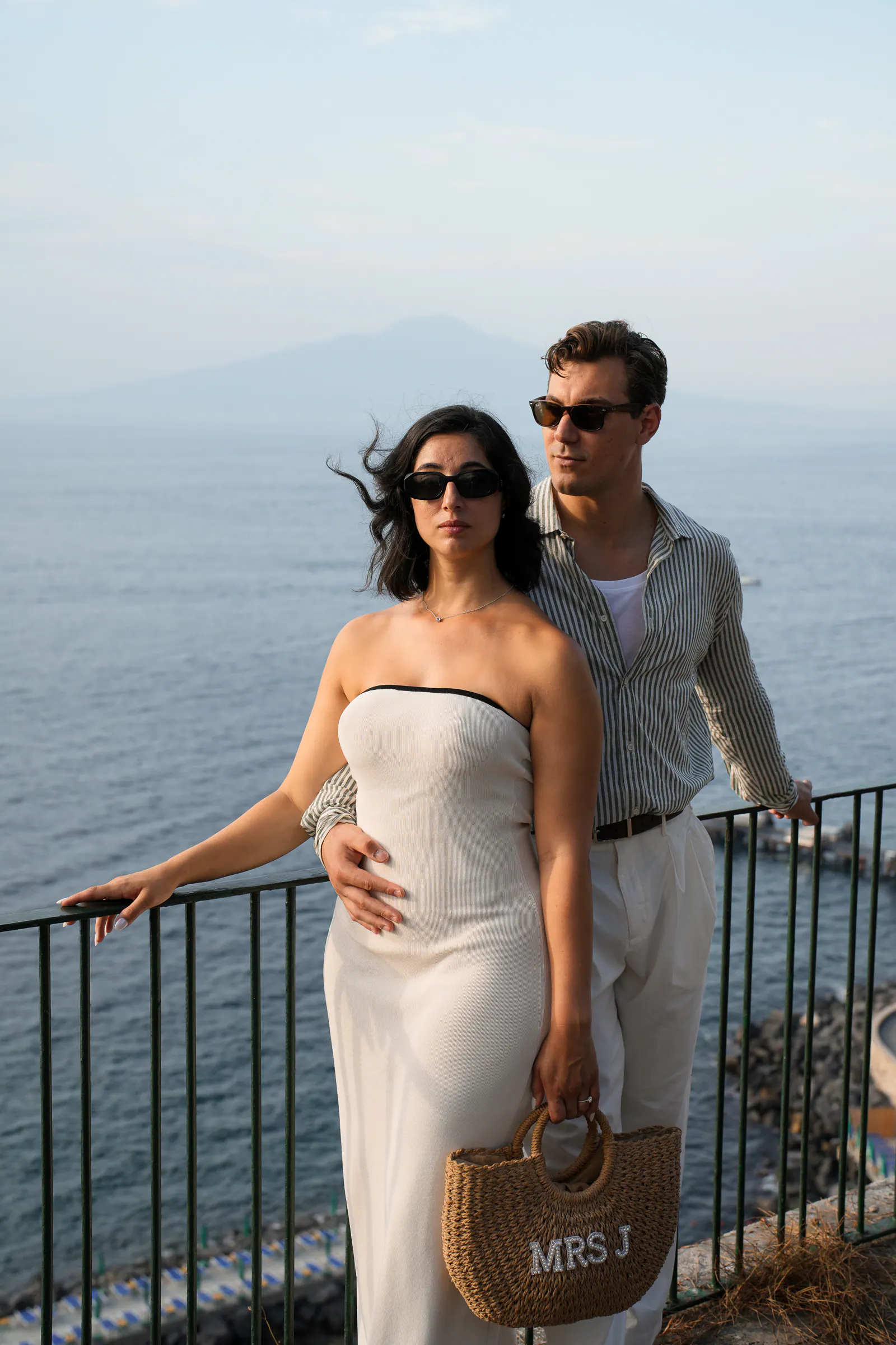 Couple at a railing in Sorrento, Vesuvius across the bay behind them.