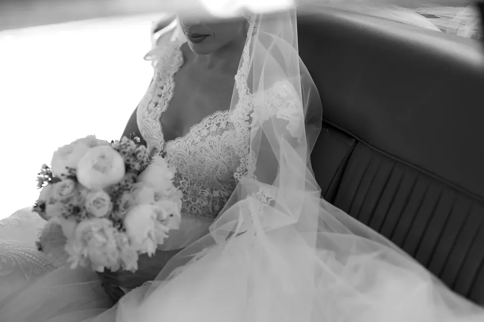 The bouquet and the lace of the gown in soft light.