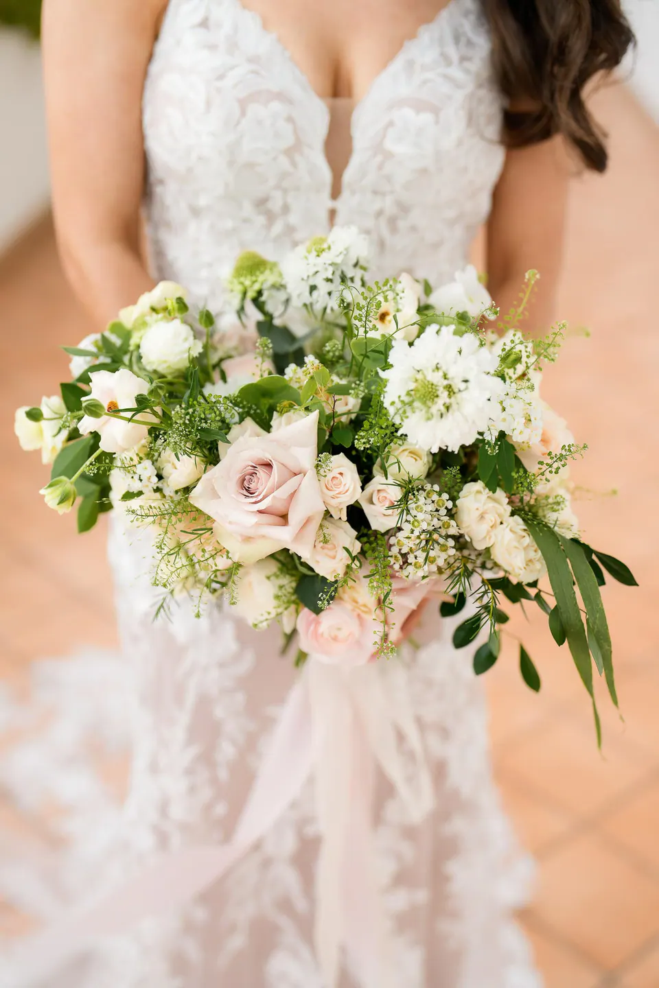 Il bouquet della sposa con rose rosa cipria e verde.