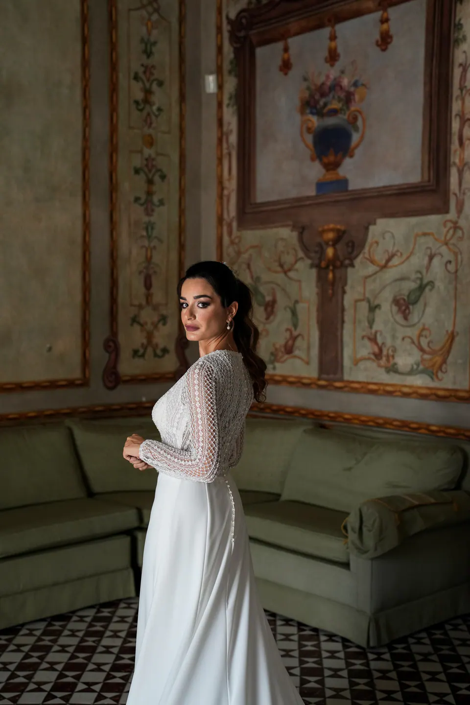 Bride leaning against a painted wall.