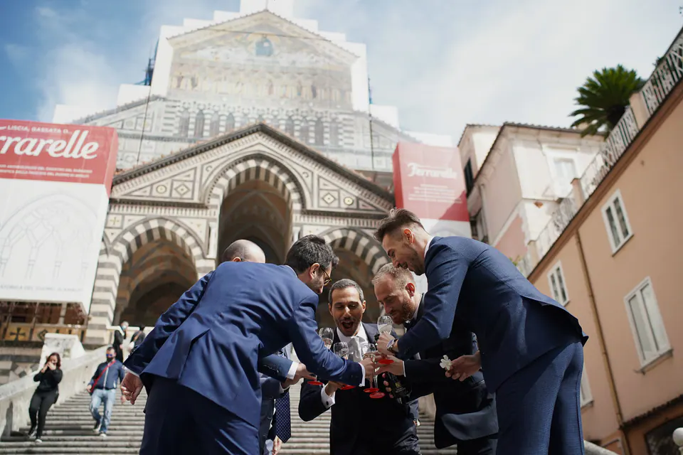 Groomsmen in blue suits in front of the Amalfi Cathedral before the ceremony.