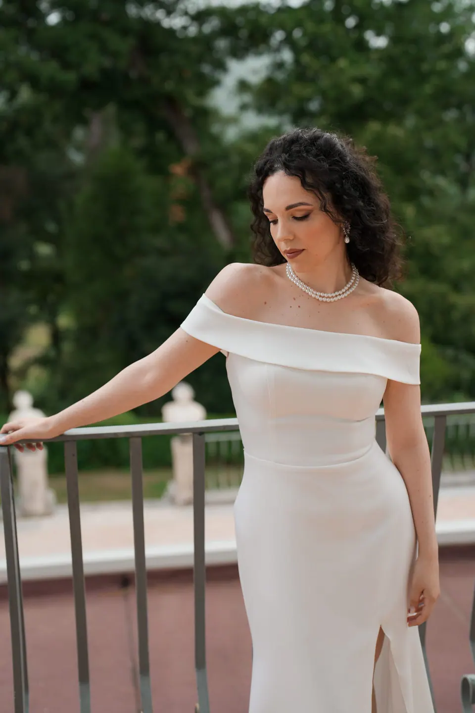 La novia sujeta la barandilla de la terraza sobre los jardines de Villa Ortensia D’Avalos.