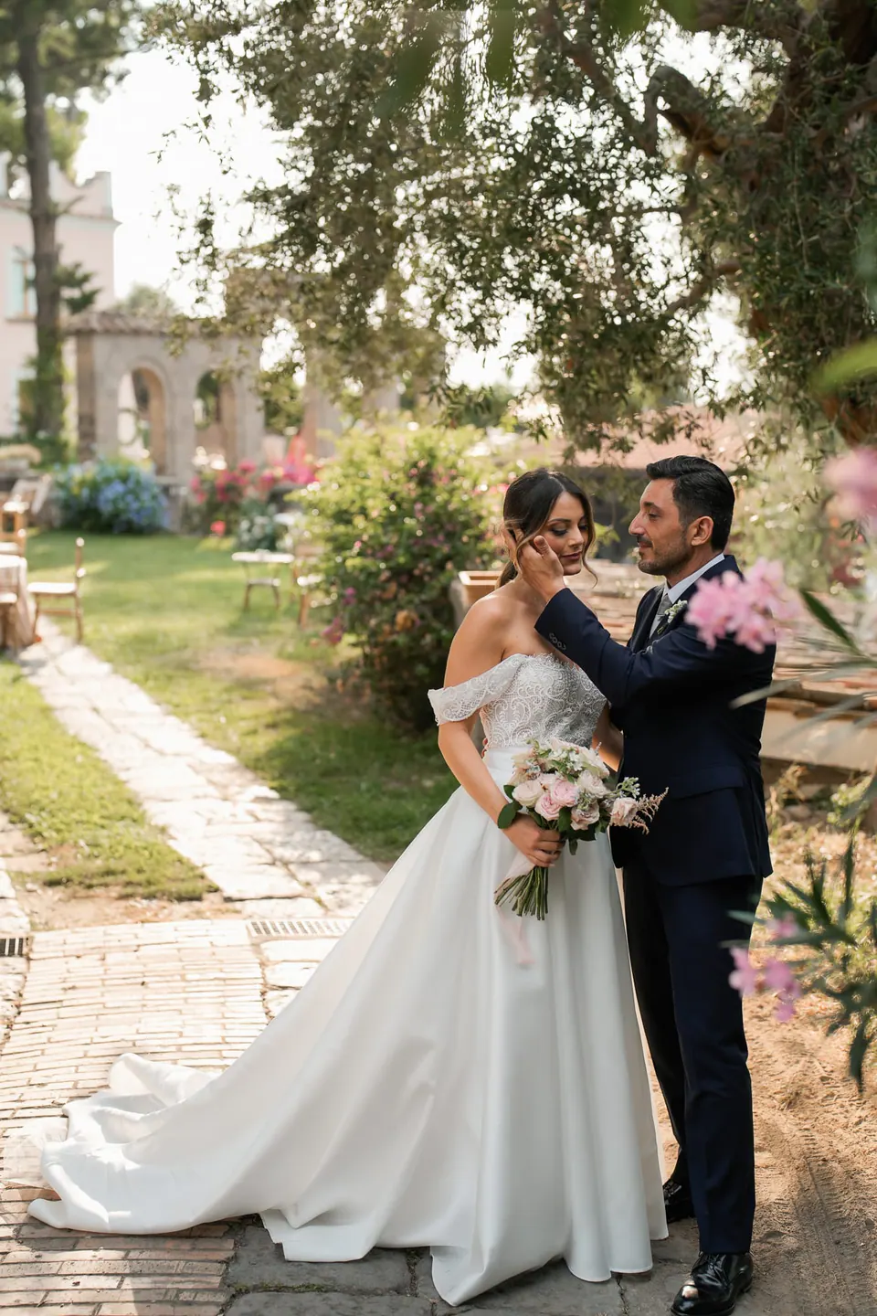 Bride and groom walking hand in hand down the garden path at Capo Santa Fortunata.