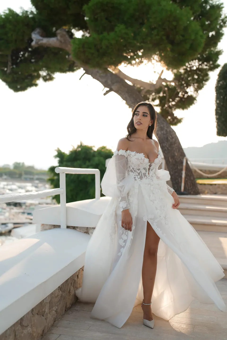 Bride walking across the terrace of Villa Scalera beneath an umbrella pine, the slit of her gown in the breeze.