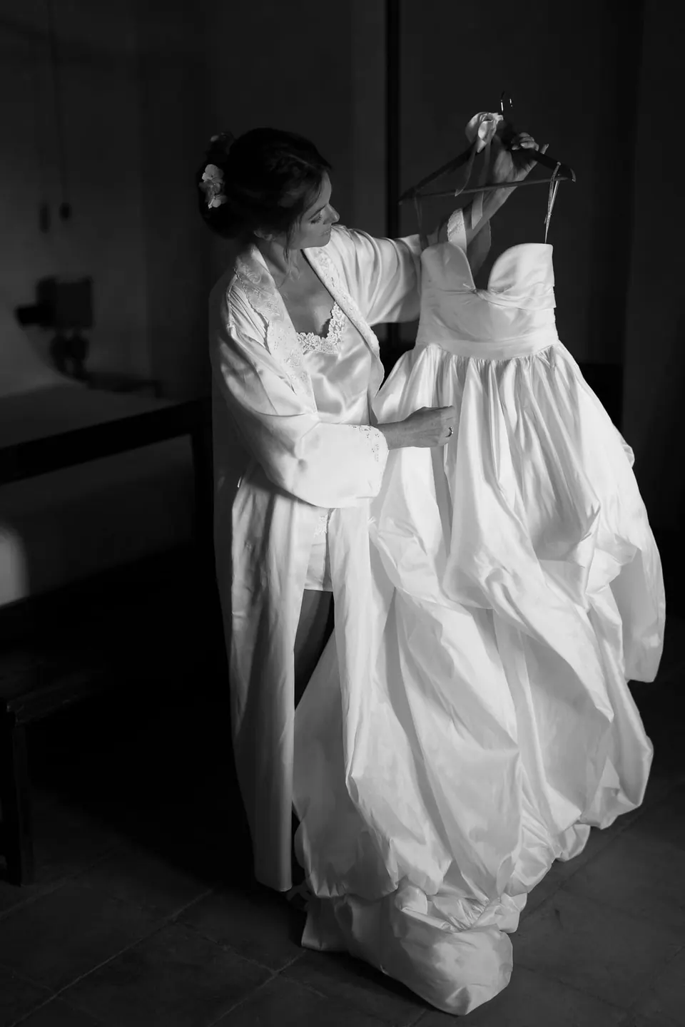 Foto in bianco e nero dell'abito sollevato sopra la sposa.