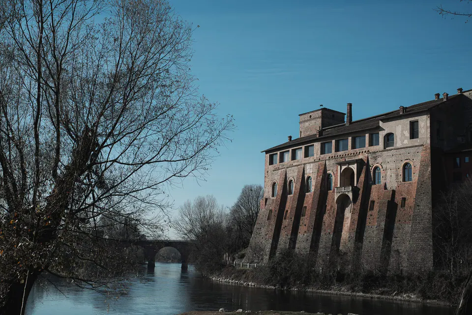 Außenansicht des Castello Visconteo am Fluss, die Backsteinmauern im Nachmittagslicht.
