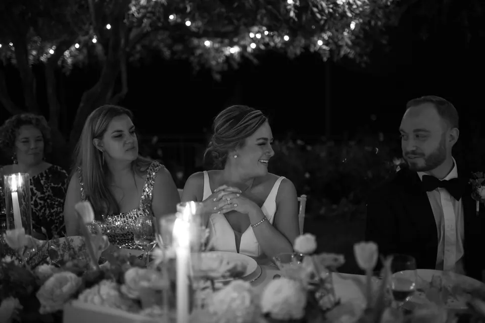 Black and white photo of the bride talking with guests at the dinner table