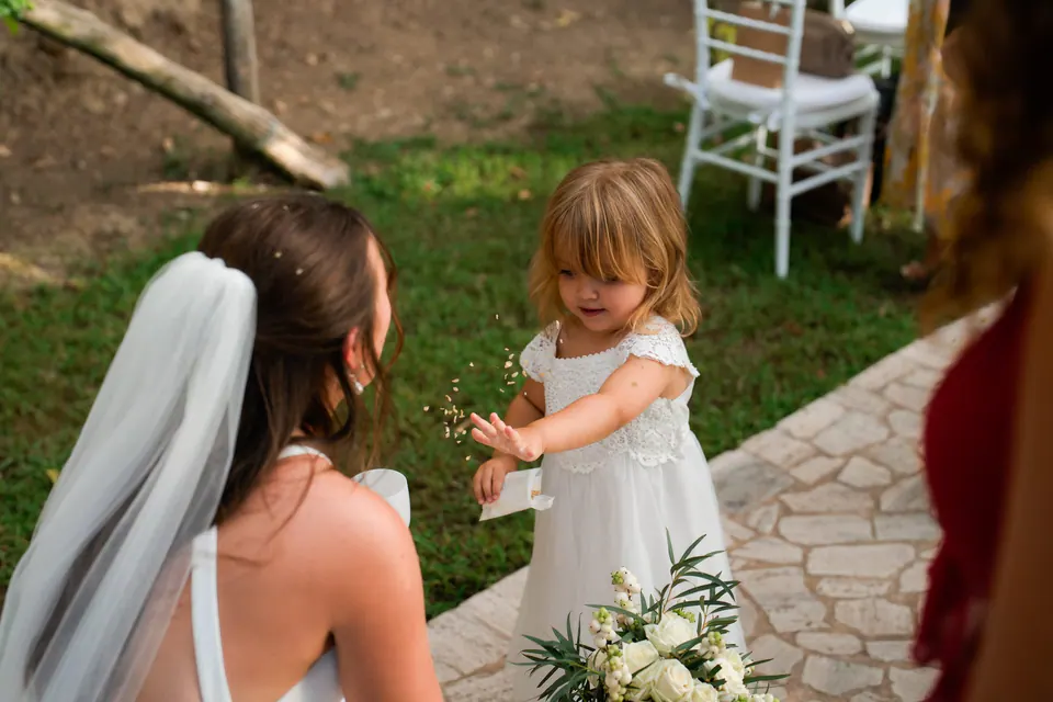 Bride with a little flower girl on the lawn before the ceremony.