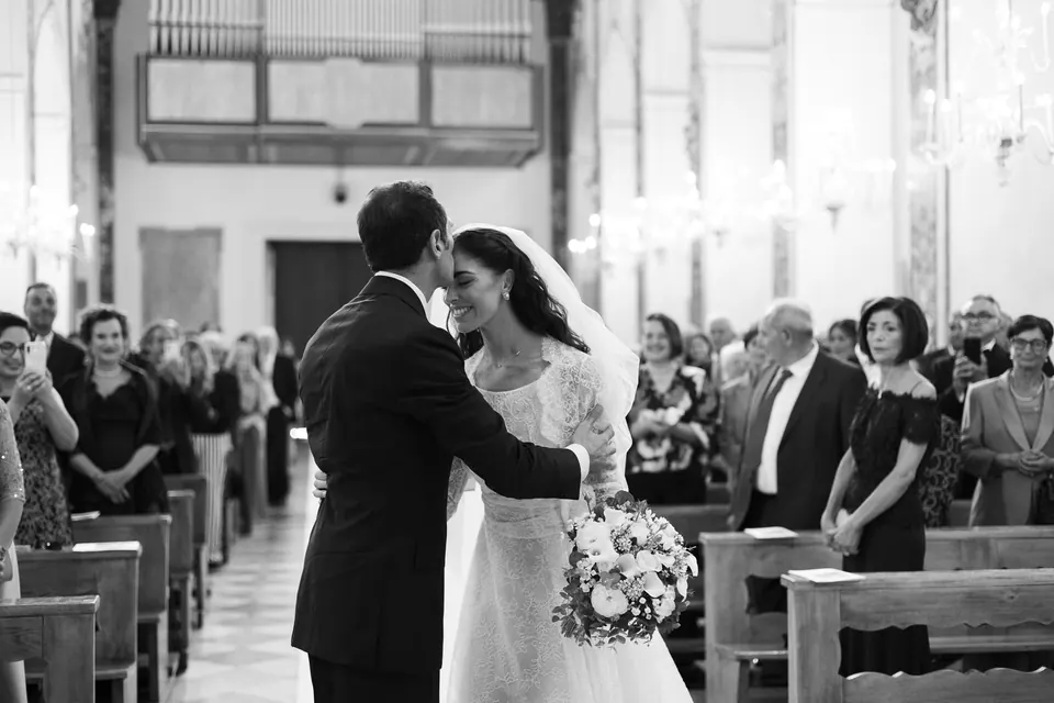 Black and white photo of the groom greeting the bride at the altar in the Duomo di Amalfi.