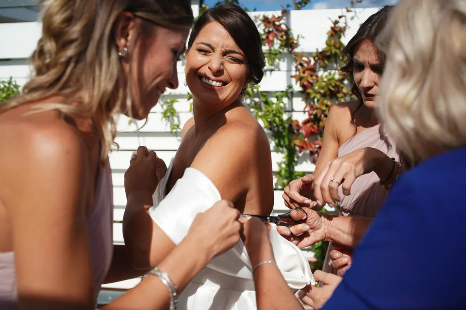 Bridesmaids laughing with the bride before the ceremony, joyful and affectionate moment.