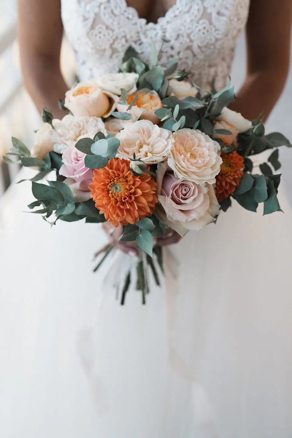 Bridal bouquet of peach and ivory flowers.