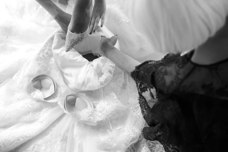 Black and white close-up of wedding rings on lace