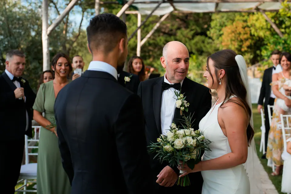 Father of the bride walking her down the aisle to the waiting groom.