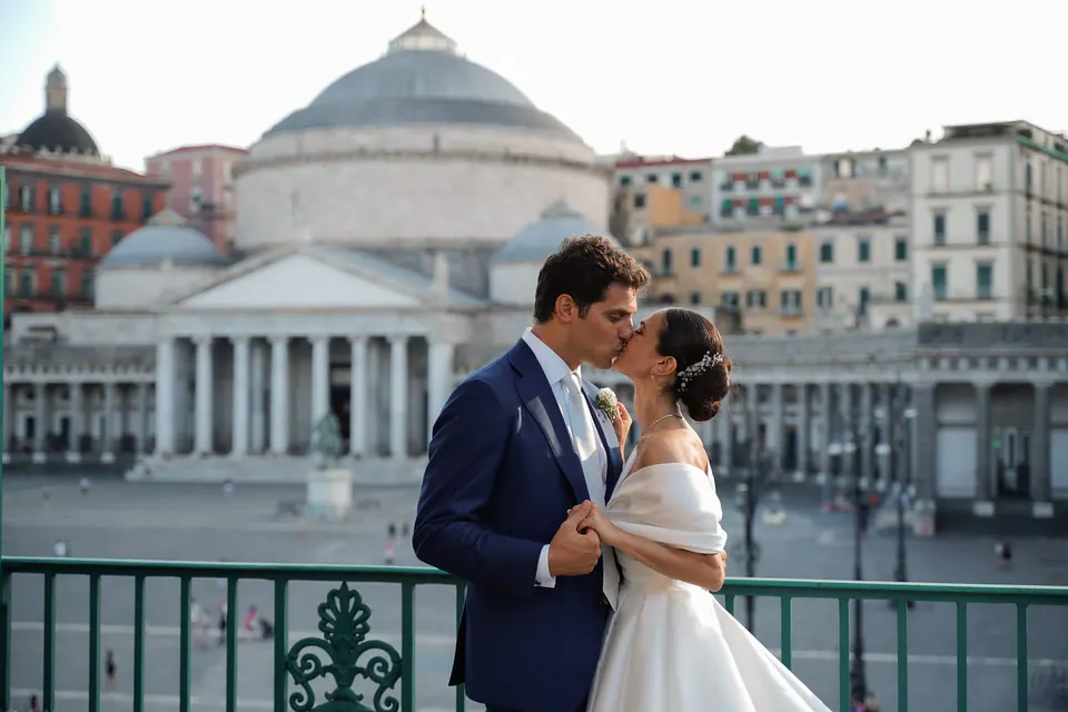 Sposi abbracciati su un balcone sopra Piazza del Plebiscito.