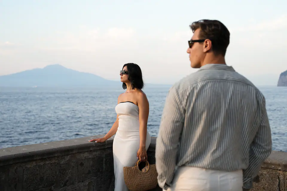 Couple looking out to sea, Vesuvius on the horizon.
