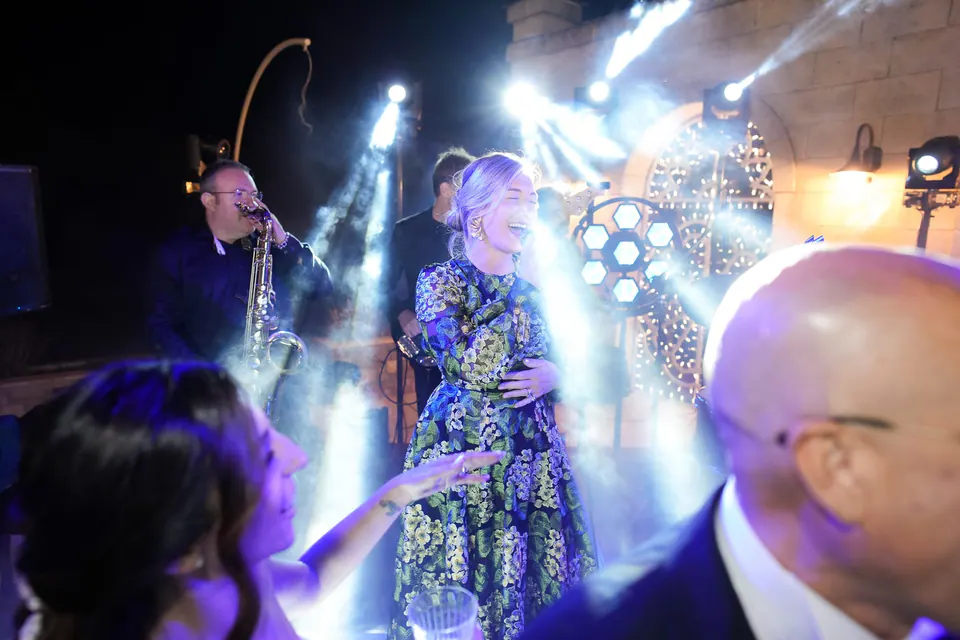 Guests dancing under colorful stage lights, joyful celebration at the wedding reception in Tenuta San Domenico.