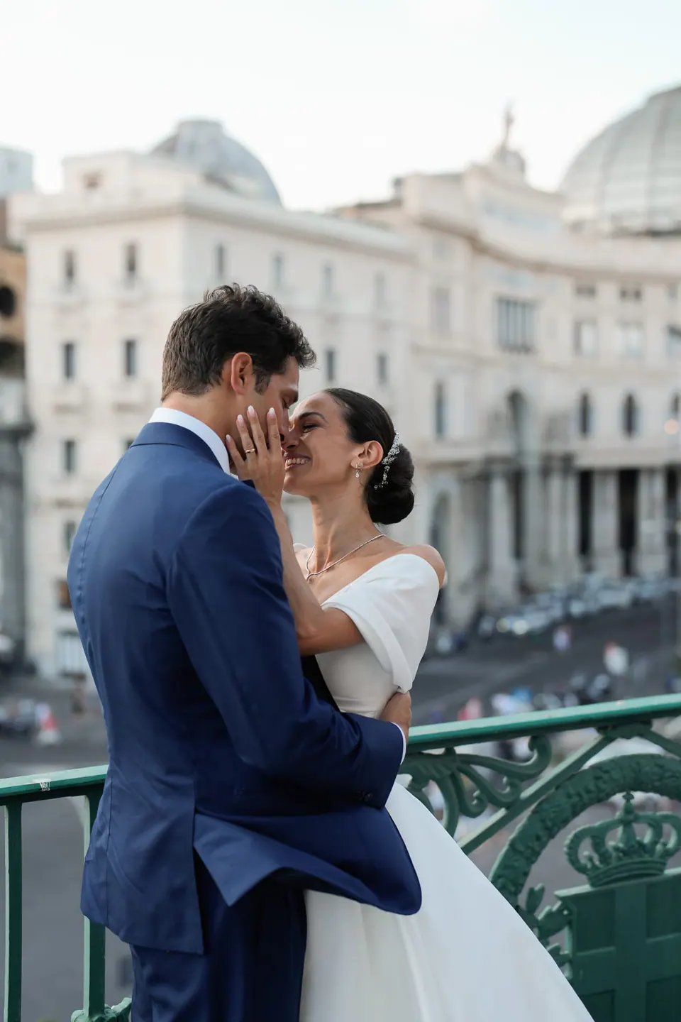 Bacio degli sposi su un balcone sopra Piazza del Plebiscito.