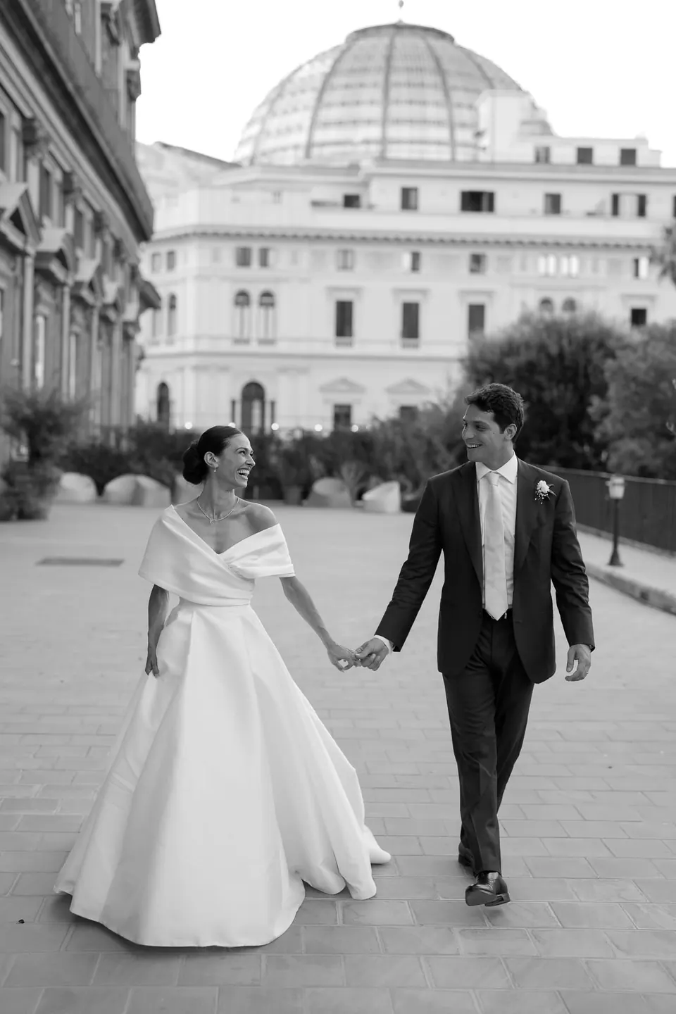 Foto in bianco e nero degli sposi mano nella mano in Piazza del Plebiscito a Napoli.