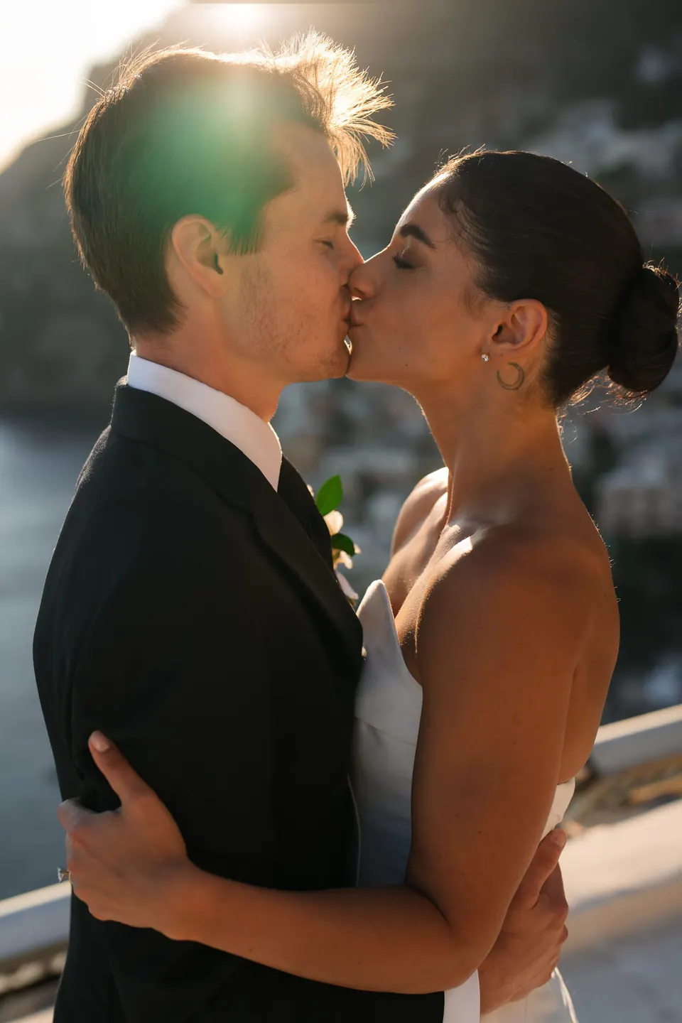 Bride and groom kissing in the sunset light.