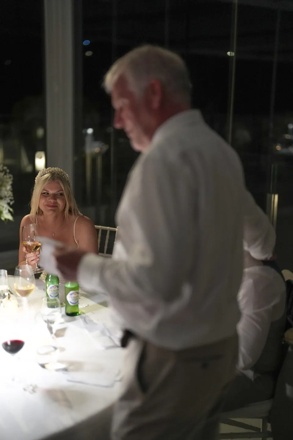 An older guest giving a speech at dinner