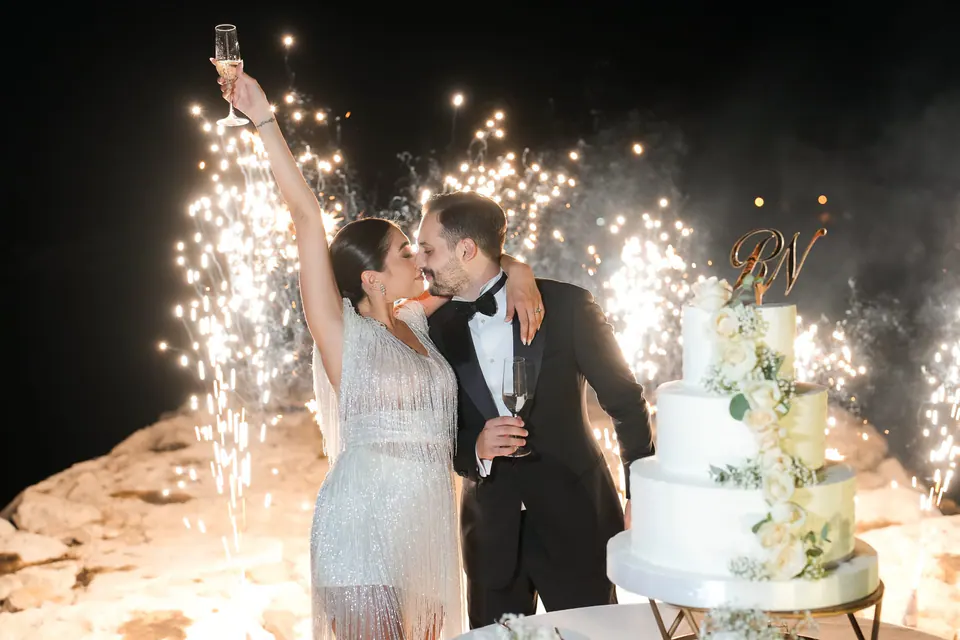 Couple sharing a kiss under a cascade of sparklers during the evening celebration.
