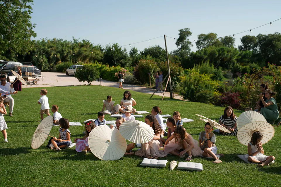 Guests relaxing on the lawn surrounded by greenery and the evening sun.