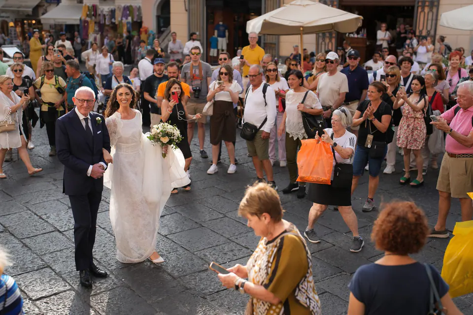 Bride and her father walking through the crowd of onlookers in Amalfi.
