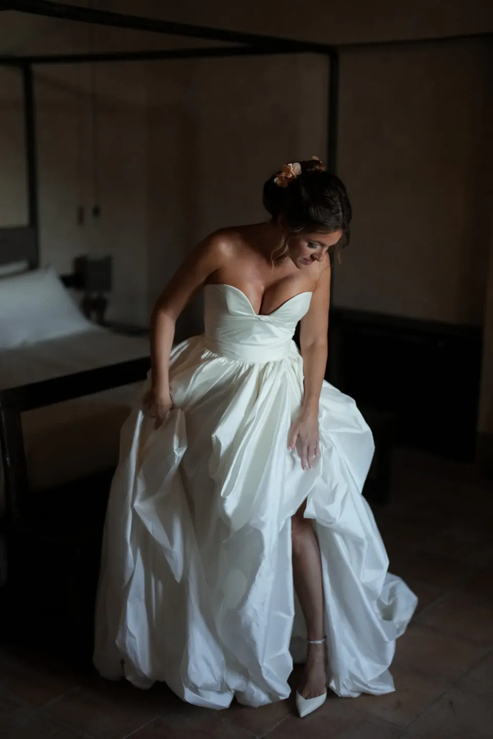 Sposa che avanza con l'abito in camera, una gamba in avanti.