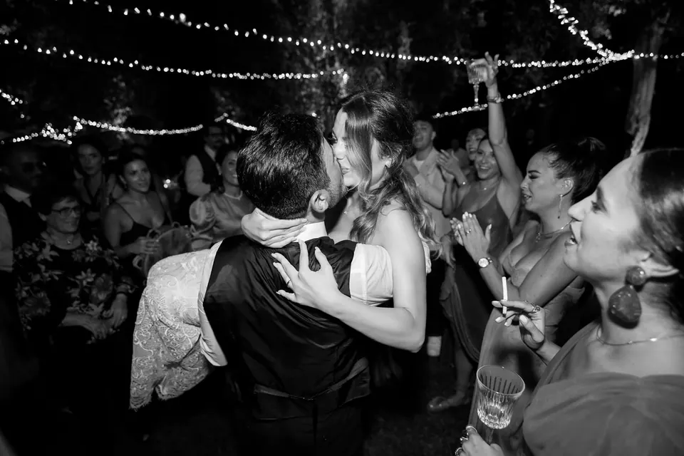 Guests dancing under twinkling string lights, music and joy filling the night.