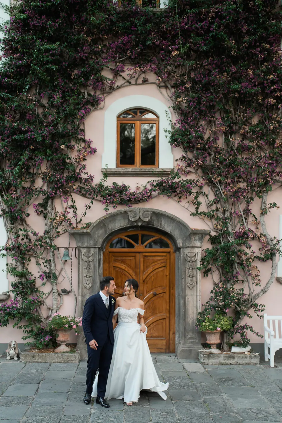 Bride and groom in front of the villa's ivy-covered entrance