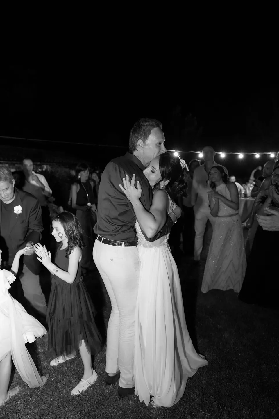Black and white photo of the groom dancing with a little girl