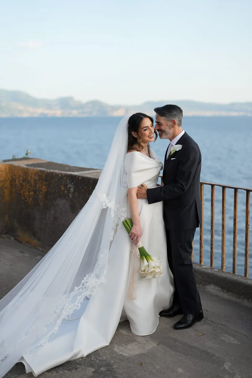 Los novios en una terraza sobre el mar.