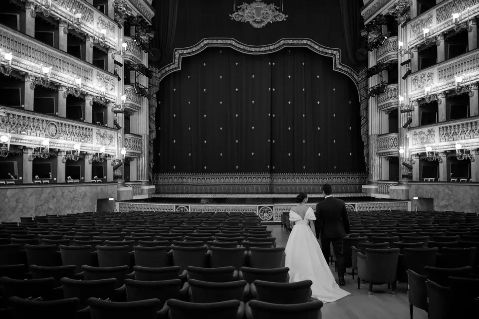 Foto in bianco e nero degli sposi sul palcoscenico vuoto del Teatro San Carlo.