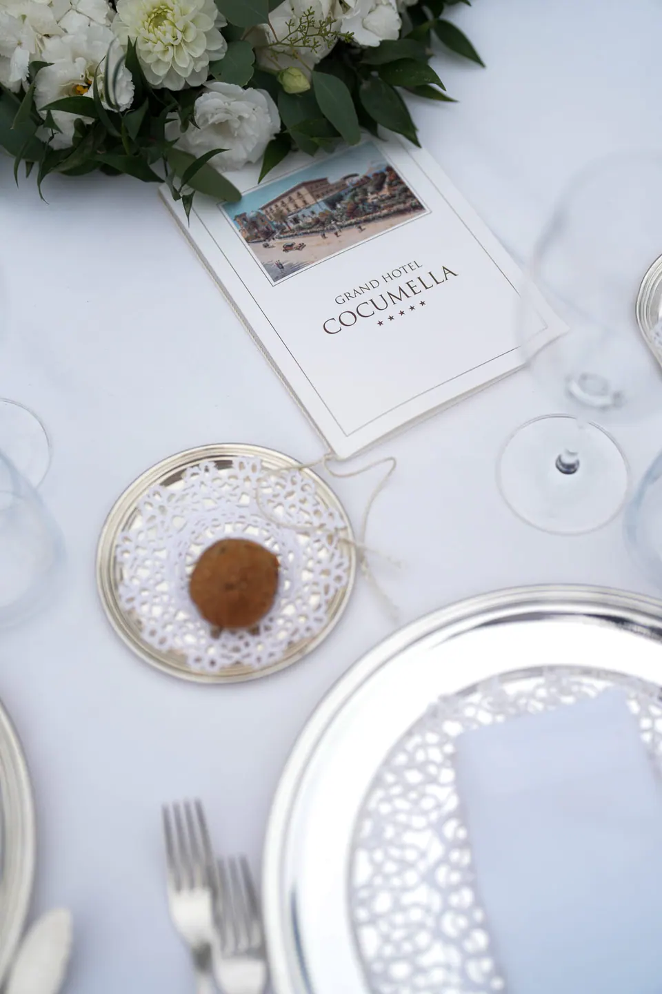 Table setting with the La Cocumella menu and a small pastry