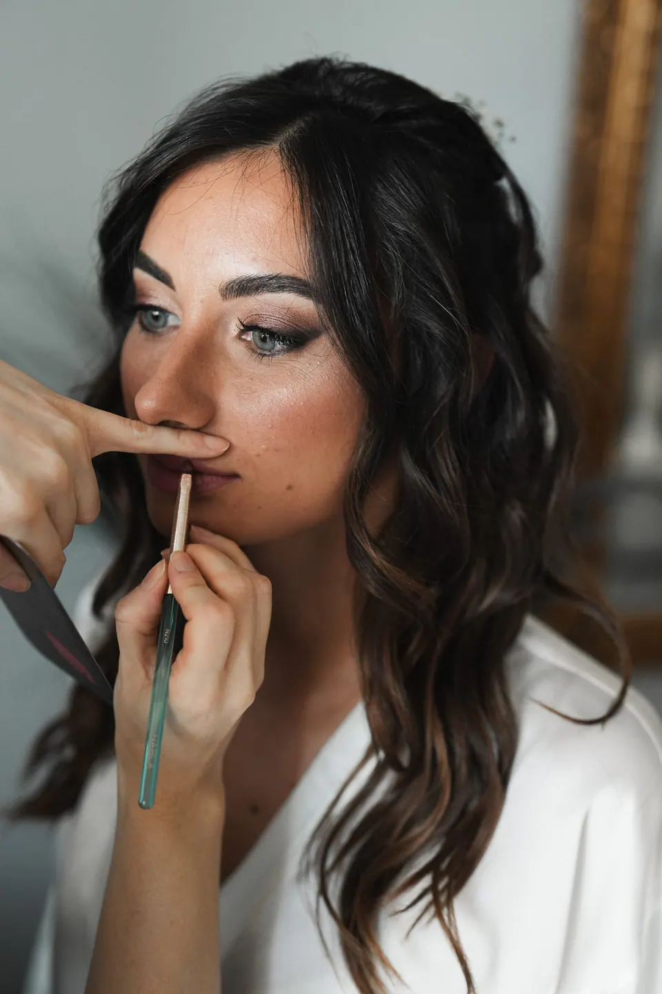 La sposa si mette il rossetto prima della cerimonia.