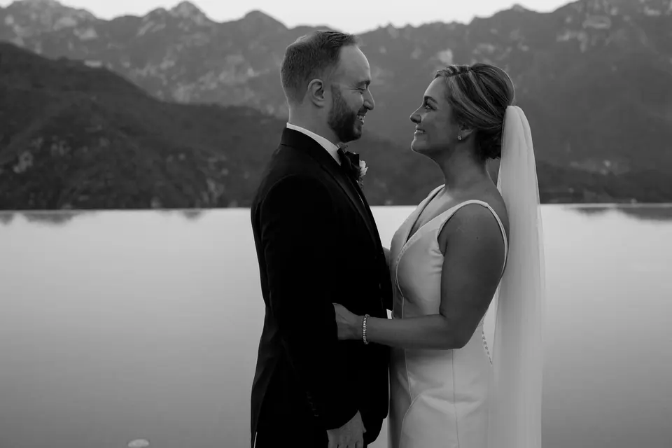 Bride and groom embracing at sunset by the infinity pool, sky and sea blending in perfect harmony.