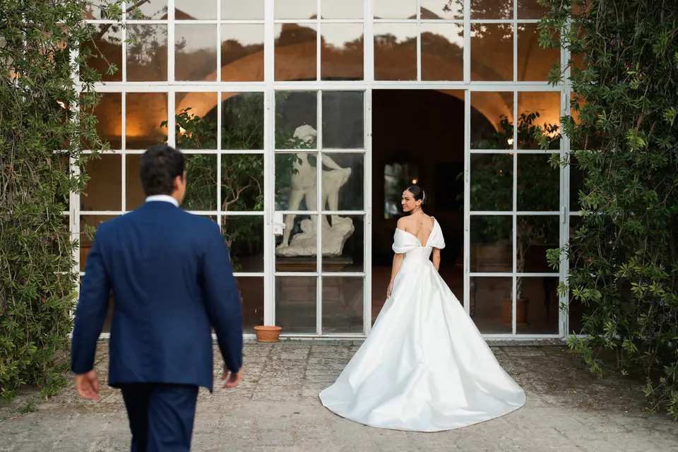 Lo sposo va incontro alla sposa davanti all'orangerie di Torre San Severino per il first look.