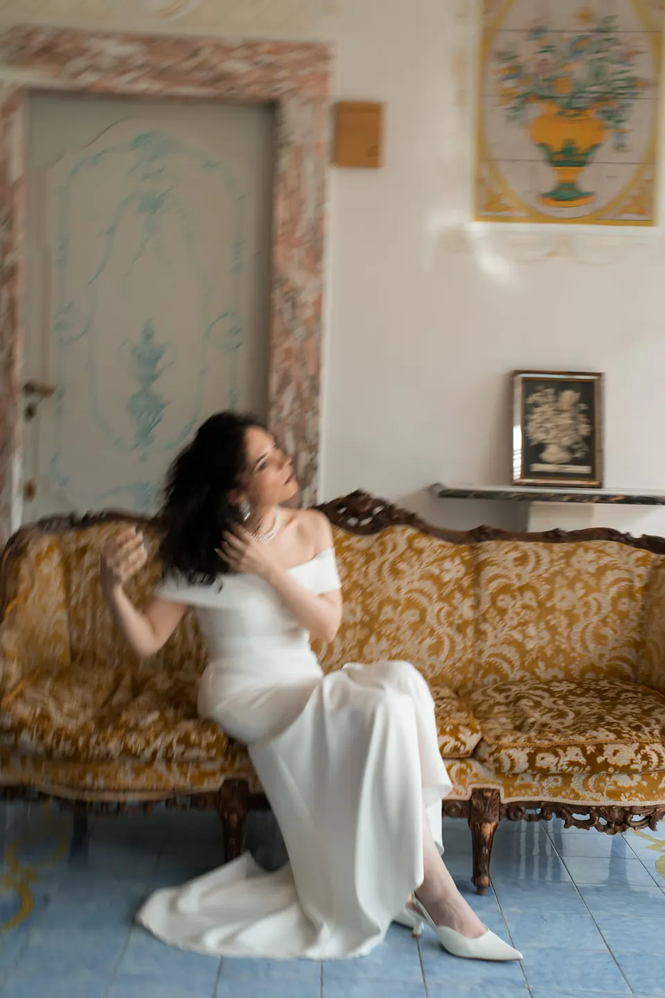 La novia sentada en un sofá antiguo.