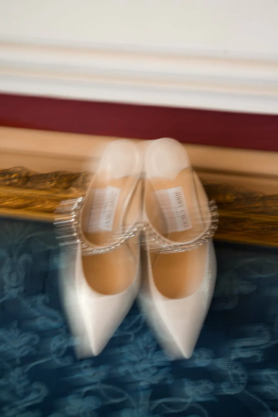 Satin bridal shoes with crystal straps on a blue carpet