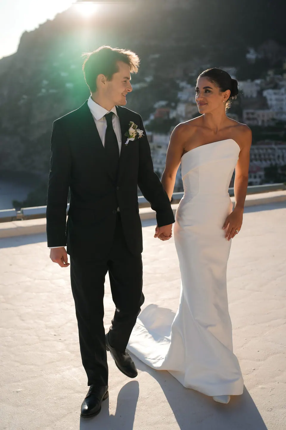 Bride and groom walking on the terrace in the evening light.