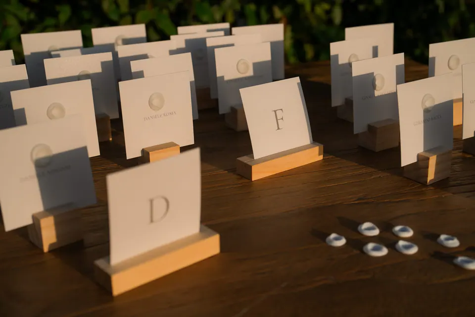 Place cards on a wooden table for the wedding dinner.