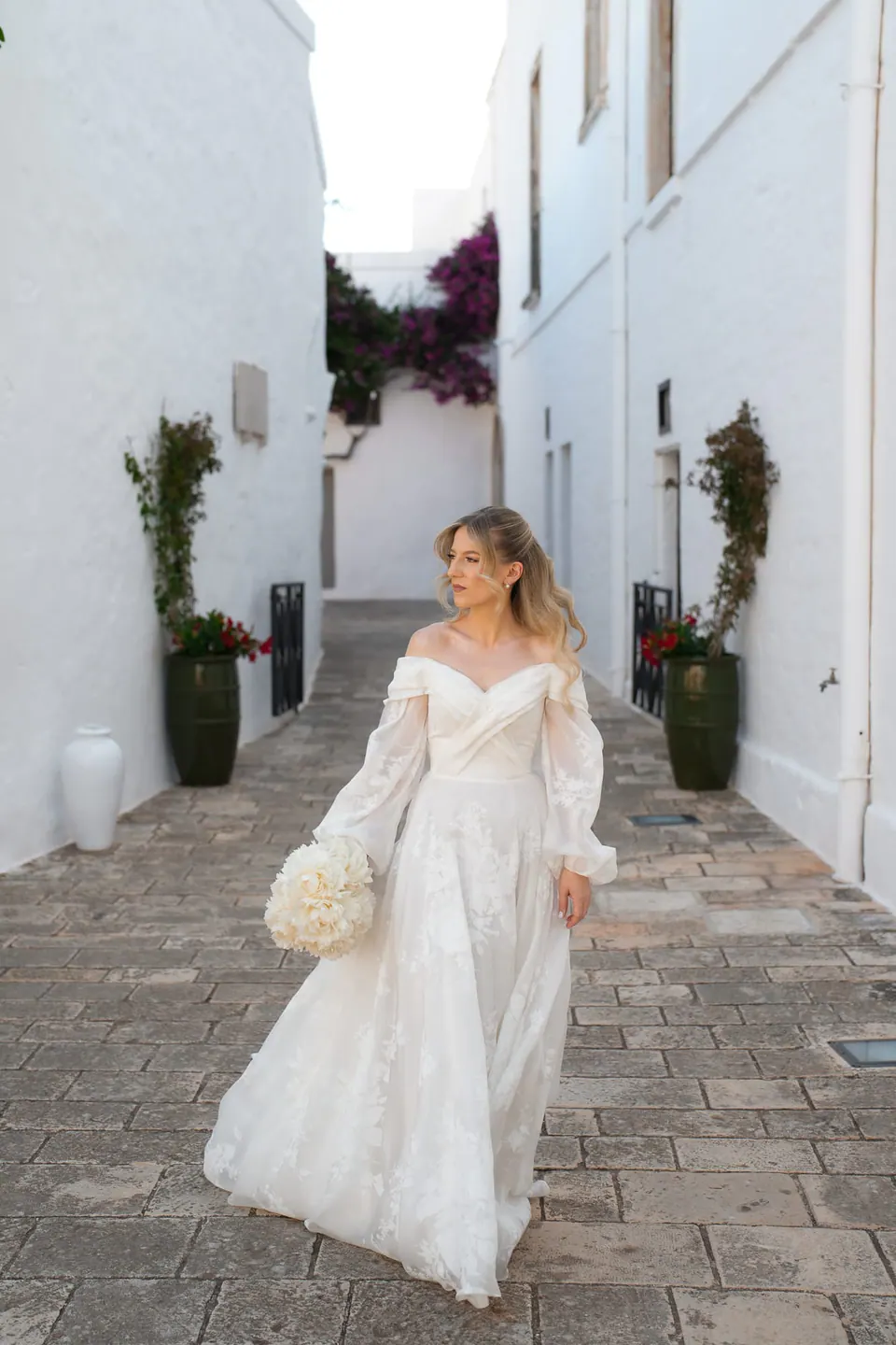 La novia junto a una casa tradicional encalada en Apulia.