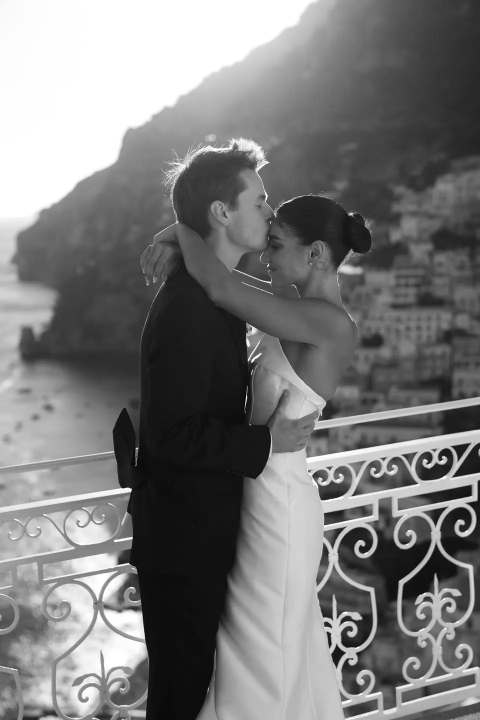 Black and white photo of the couple embracing at the railing.