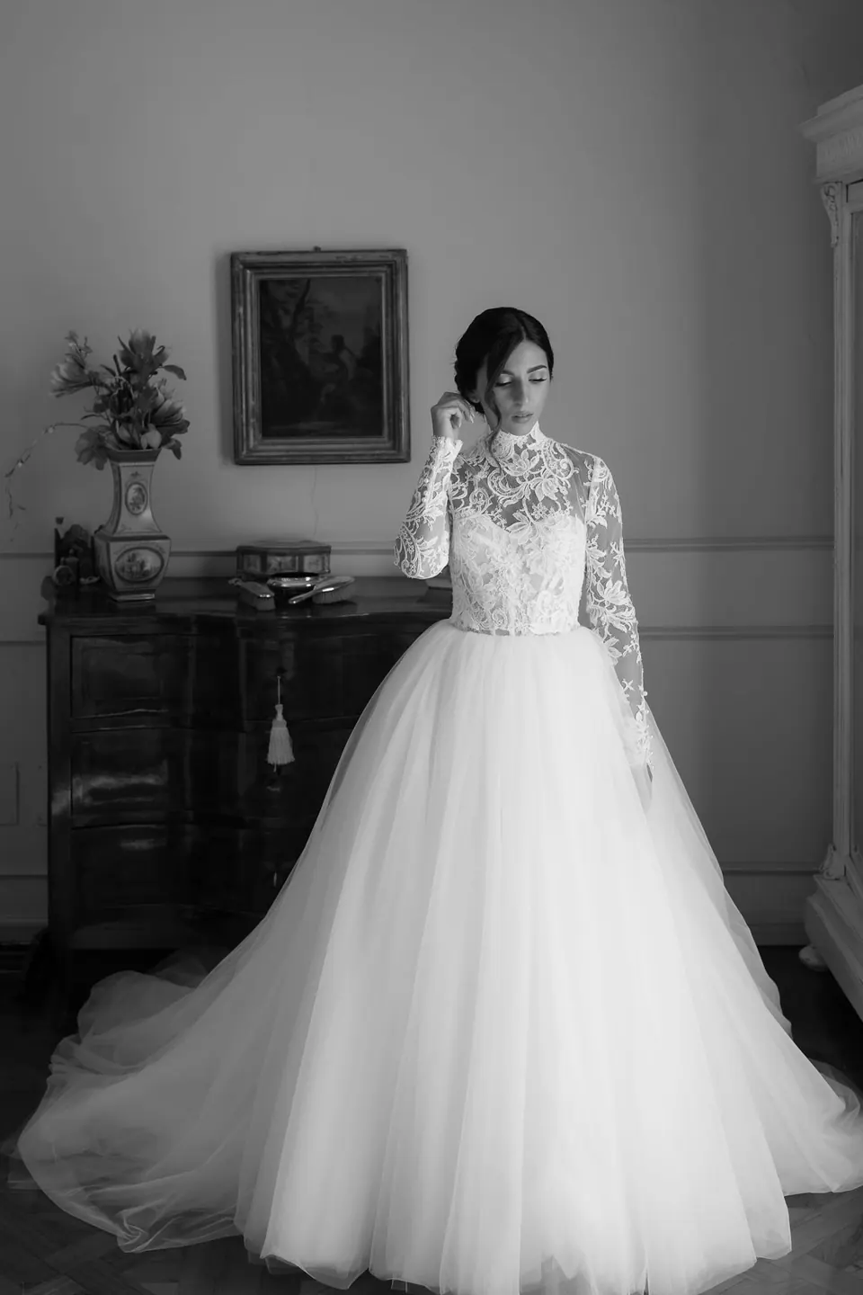 Bride in a ball gown in the grand hall of the villa, under warm light.