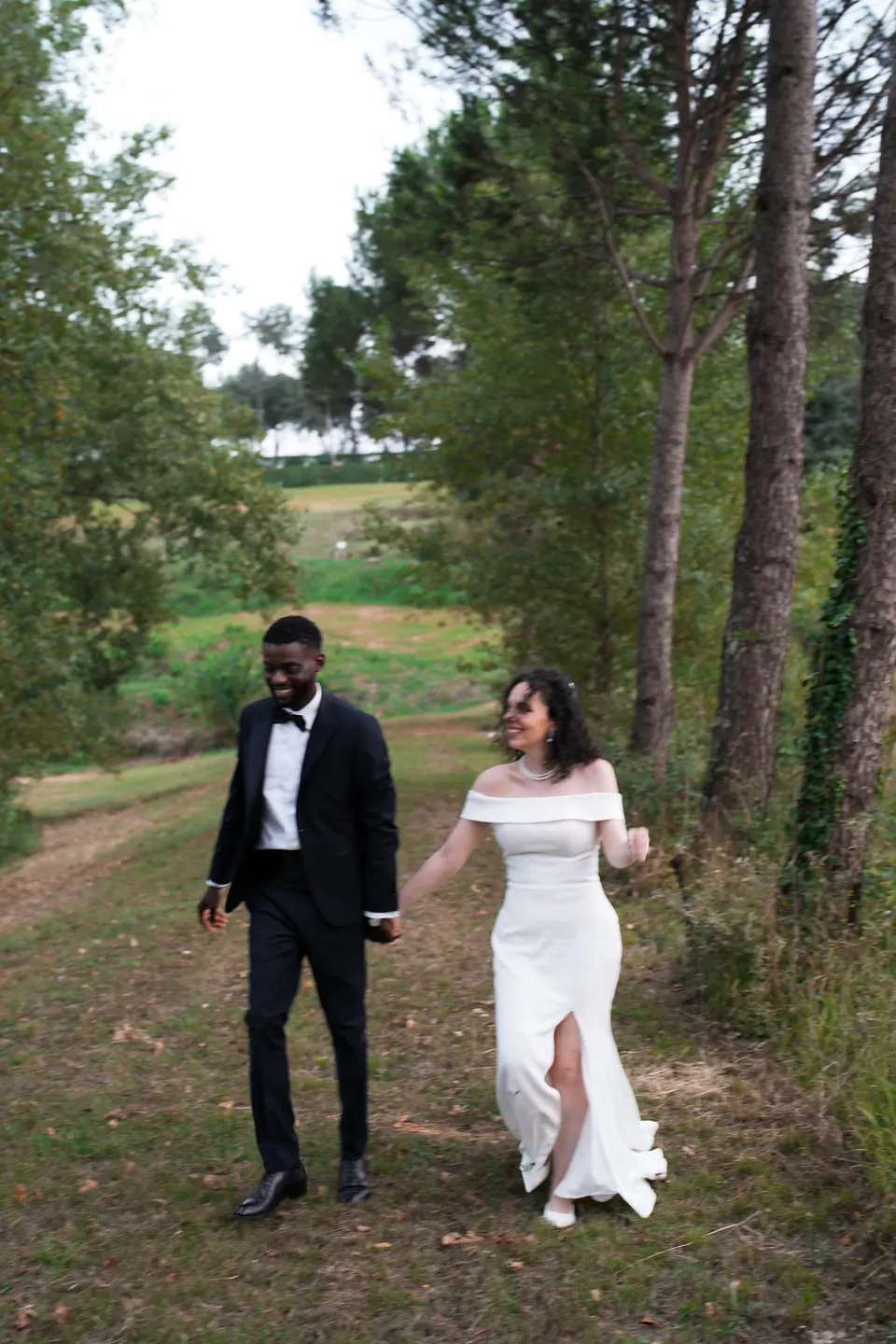 Los novios caminan por un sendero del bosque en el parque de la villa.